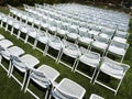 Symmetrical Pattern Of White Folding Chairs At Outdoor Garden Event