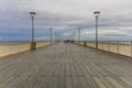 Symmetrical view to beautiful long water pier over Baltic sea at cloudy stormy day