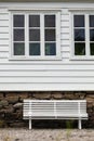 Symmetrical white bench in front traditional house.