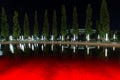 Symmetrically arranged trees with lanterns along the fountain in the Park of Krasnodar. Decorative pool or fountain with colored