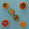 Symmetrically arranged tropical fruit and leaves, with half strawberry on beige background. Minimal flat lay