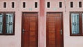 Symmetry wooden door and windows in the pale pink wall