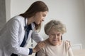 Sympathetic geriatrician embracing serious lost elderly patient with support