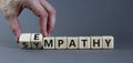 Sympathy or empathy symbol. Businessman turns wooden cubes and changes the word `empathy` to `sympathy`. Beautiful grey backgr