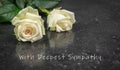 Two white roses on a dark background. With Deepest Sympathy text.