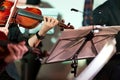 Symphony music. Woman playing the violin in orchestra near music note stand