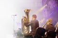 Symphony orchestra on the stage, orchestral brass section, behind the scenes shoot.Tubaist in black shirt blow in big brass tube Royalty Free Stock Photo