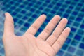 Symptom pruney and wrinkled skin hand and finger from water on blue pool swimming background at morning sunrise,Skin symptoms of