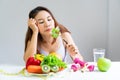 Symptoms of anorexia manifested in aversion to food. Portrait of young Asian woman in unsatisfied facial emotional expression,