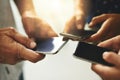 Synced to the smart age. Closeup shot of a group of unrecognizable businesspeople using their cellphones in