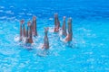 Synchronised swimming. Beautiful lean female legs in the water of a swimming pool. Concept of beauty, artistry