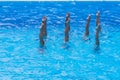 Synchronised swimming. Beautiful lean female legs in the water of a swimming pool. Concept of beauty, artistry