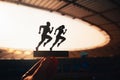 Synchronized Strides: Silhouettes of Male and Female Runners in Tandem, Modern Sports Stadium Backdrop