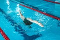 Synchronized swimming athlete trains alone in the swimming pool. Training in the water upside down. Legs peek out of the water.