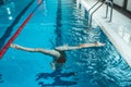 Synchronized swimming athlete trains alone in the swimming pool. Training in the water upside down. Legs peek out of the water. Royalty Free Stock Photo