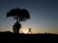 synergetic and dynamic human silhouette next to the only tree in nature Royalty Free Stock Photo