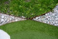 syntetic grass and real grass separated by iron and white rocks.. Royalty Free Stock Photo