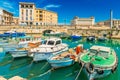 Cityscape of Syracuse with colorful boats, bridge and historical buildings with blue sky in the background