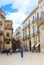 Syracuse, Sicily, Italy - Apr 10th 2019: Tourists walking on the Piazza Duomo Square in the old town. The historical center