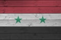 Syria flag depicted in bright paint colors on old wooden wall. Textured banner on rough background