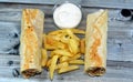 Syrian recipe cuisine background, chicken shawerma or shawarma tortilla wrap with onion, tomato, lettuce and garlic sauce in