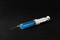 Syringe with blue liquid, on a black background. Hospital, clinic, medical supplies Royalty Free Stock Photo