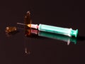 A syringe and a broken ampule on dark background Royalty Free Stock Photo