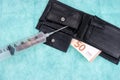 Syringe with coins and fifty euro bill in the leather wallet Royalty Free Stock Photo