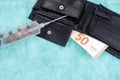 Syringe with coins and fifty euro bill in the leather wallet Royalty Free Stock Photo