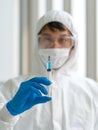 A syringe containing a blue anti-virus drug in the hands of researchers