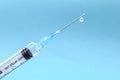Syringe with a drop of medication at the end of the needle on a blue gradient background health concept Royalty Free Stock Photo