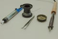 A syringe for the extraction of solder, coil of tin, a soldering iron and tweezers