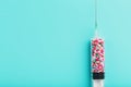 Syringe filled with colorful nano balls on a light blue background