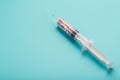 Syringe filled with colorful nano balls on a light blue background