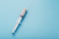 Syringe filled with colorful nano balls on a light blue background