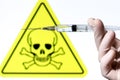 Syringe filled with liquid on white background with danger symbol