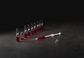 Syringe filled with red liquid from broken ampule on dark background. Low key photo. Medicine, healthcare and pharmacy Royalty Free Stock Photo