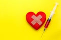 Syringe give medicine to red heart shape on yellow background. U