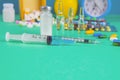 Syringe with glass vials and medications pills drug. In the background is a wood box and a yellow apple. Front views