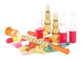 Syringe with glass vials and medicinal tablets and pills isolated on a white background.