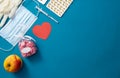 Syringe, gloves, heart, apple, pills, mask lie on the table Royalty Free Stock Photo