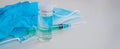 A syringe, gloves, mask, and a bottle of vaccine stand on a blue background. For the prevention, immunization and treatment of