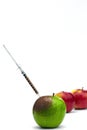 Syringe injection into a red apple. Genetic modified foods Royalty Free Stock Photo