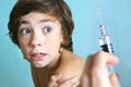 Syringe with injection vaccination. Boy is afraid. Royalty Free Stock Photo