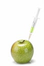 Syringe inserted in an apple. Royalty Free Stock Photo