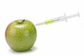 Syringe inserted in an apple. Royalty Free Stock Photo