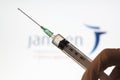 Syringe and Janssen logo on the background. Coronavirus, Covid-19 vaccine concept