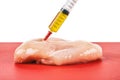 Syringe with liquid being injected to a piece of meat Royalty Free Stock Photo