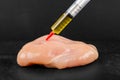 Syringe with liquid being injected to a piece of meat Royalty Free Stock Photo