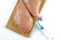 Syringe with liquid being injected to a piece of meat. Conceptual illustration for Hormones and antibiotics in food production. Royalty Free Stock Photo
